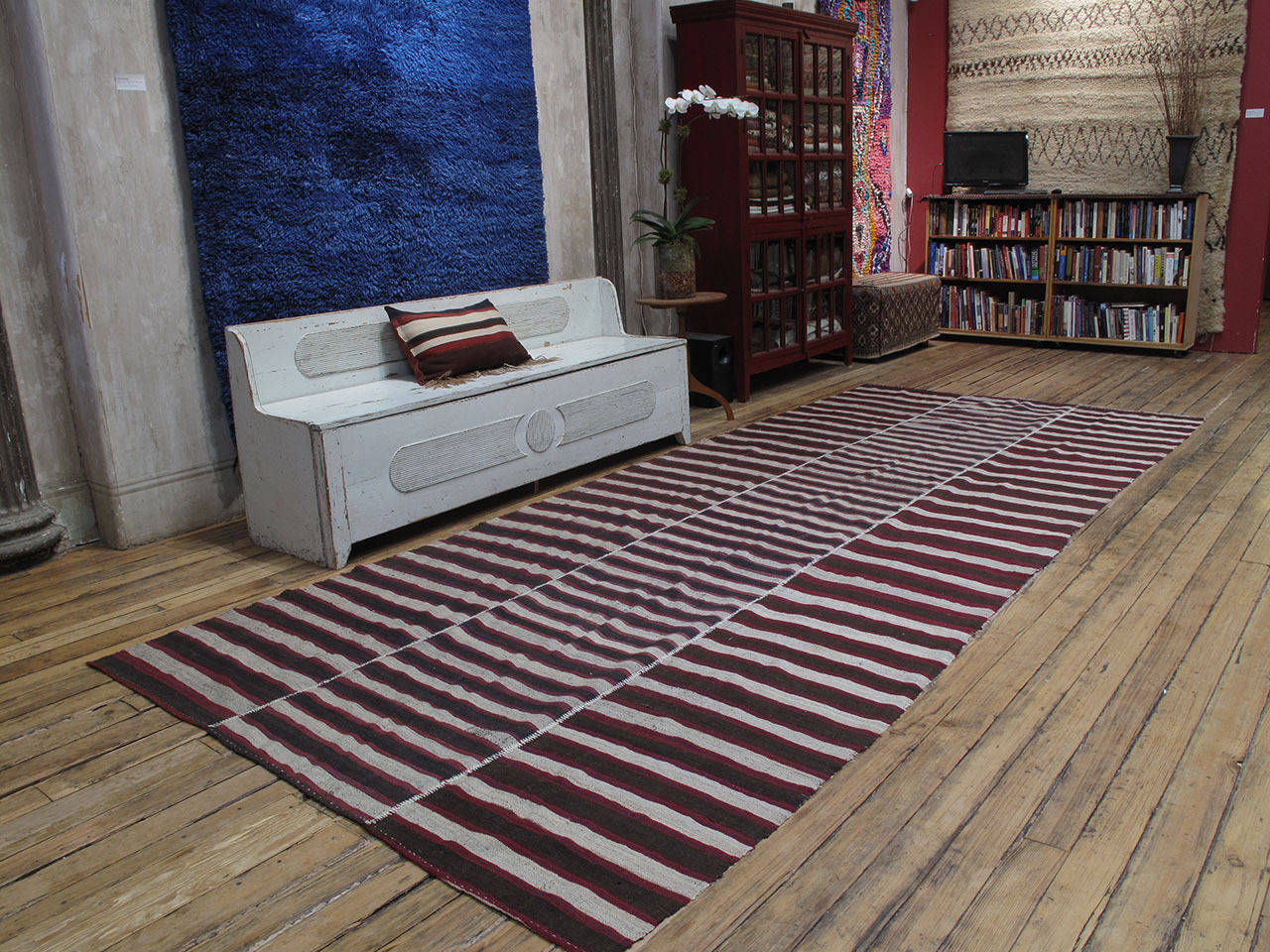 A large tribal flat-weave from Northern Iran, woven in three narrow panels with a simple design of alternating bands. The use of red and blue, in addition to the typical dark brown and ivory color palette is unusual. An authentic old weaving with