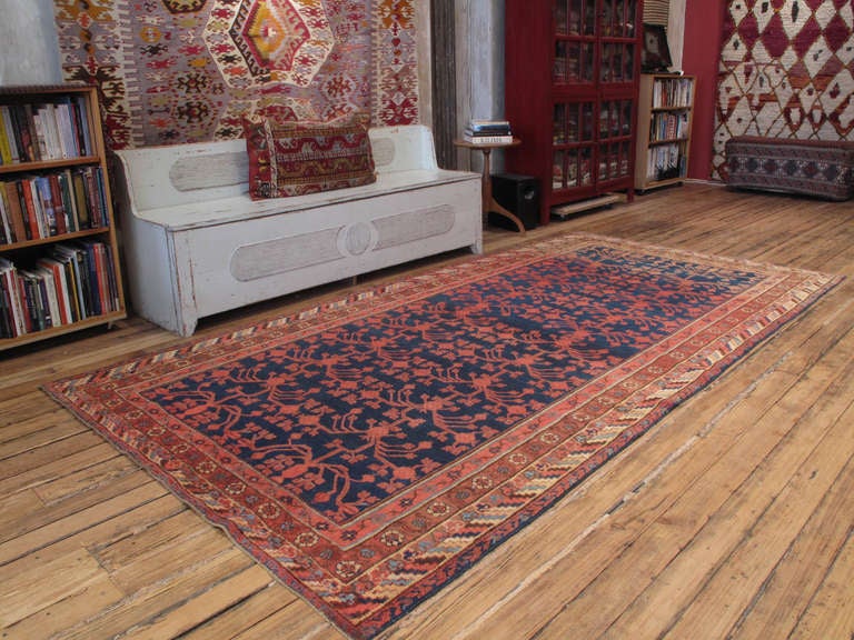 Khotan carpet or rug. Woven in the border regions of Western China, where Chinese culture meets the Turco-Persian world of Central Asia, Khotan carpets like these feature symbols and design elements of both culture. The pomegranates in the center