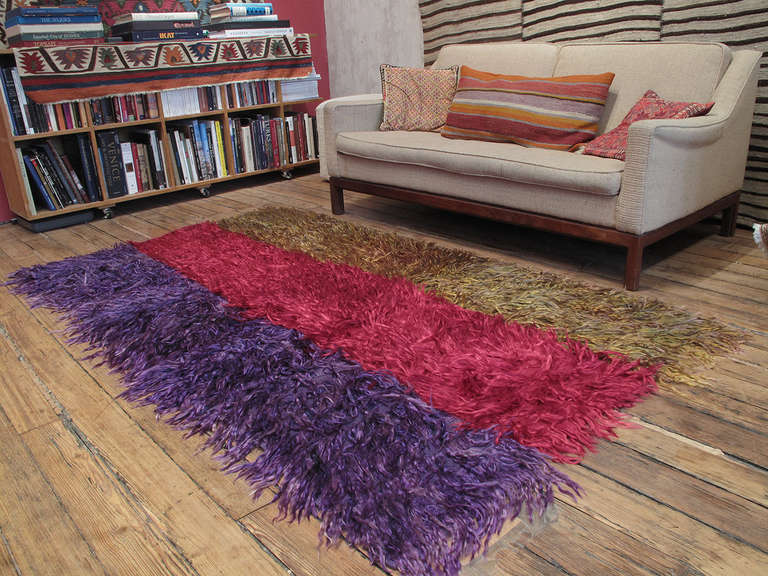 A simple old tribal rug from West-Central Turkey, woven with coarsely knotted tufts of Angora goat hair (mohair), used to provide warmth and comfort. The piece is original, woven in three narrow panels that were dyed by dipping in separate colors.
