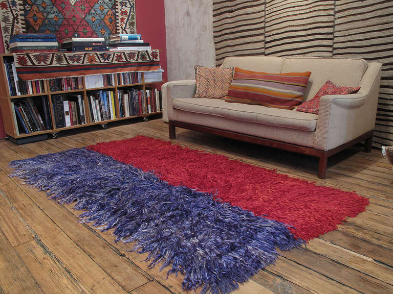 A simple old tribal rug from West-Central Turkey, woven with coarsely knotted tufts of angora goat hair (mohair), used to provide warmth and comfort. The piece is original, woven in two narrow panels that were dyed by dipping in separate colors.