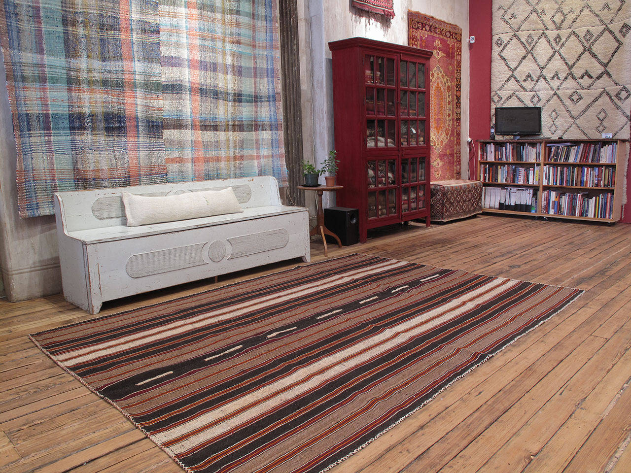 Kilim rug with vertical stripes. A tribal flat-weave from Southeastern Turkey, rug is woven with goat hair in natural tones varying from dark brown to ivory and bright red and orange stripes. A Kilim rug like this would have been used as a