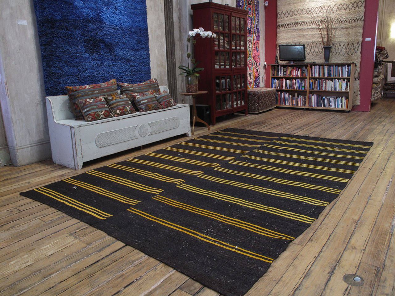 A large tribal floor cover from Southeastern Turkey, consisting of two panels stitched together. Woven with tightly spun, dark brown goat hair, decorated with bright yellow stripes and a few scattered brocaded motifs, this is a simple and Primitive