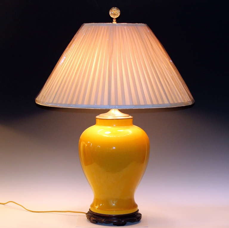 Large vintage Japanese porcelain lamp in sunny yellow glaze with carved hardwood base.