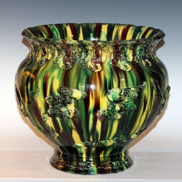 Awaji Pottery jardiniere with applied decoration of dragons amidst clouds and a three color drip glaze, circa 1920s. Measures: 12