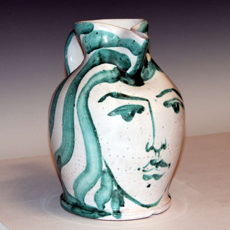 Great Robert Picault face jug, circa 1950's. Well executed piece with expressive face and flowing hair that works into the form of the pitcher. Has not become too dark and gloomy as some of his pieces can be. Impressed studio marks on foot. 9 1/4