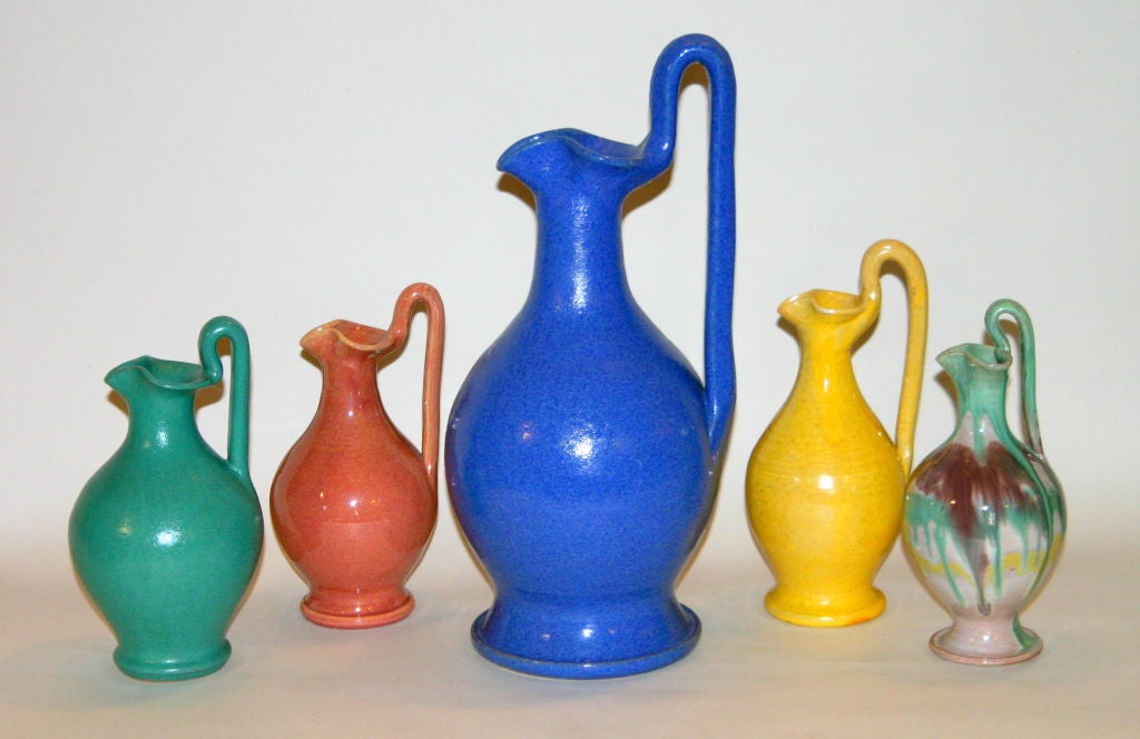 Five hand made North Carolina pottery rebecca form pitchers in different glaze colors.