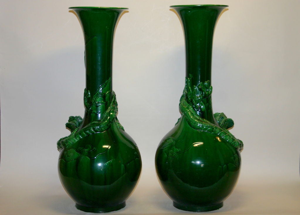 Matched pair boldly executed in high relief with coiling dragon amidst the clouds. Saturated in emerald green glaze.