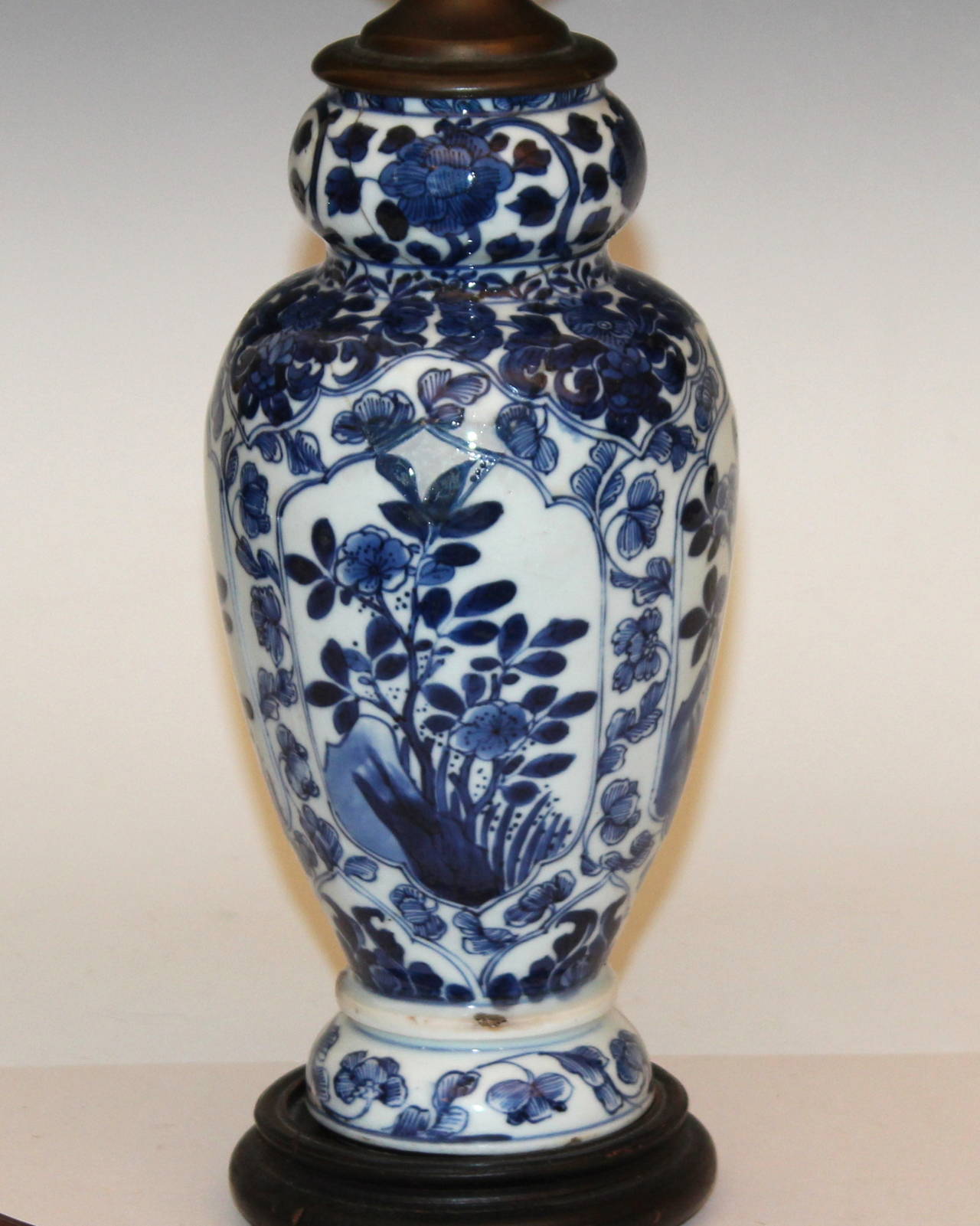 Nice antique Chinese blue and white porcelain, Kangxi period, garlic neck vase made into a lamp. Vase is 17th-18th century. Interesting form with good design of four panels of grasses, rocks and flowers surrounded by leaf and peony scrolls. Rich and