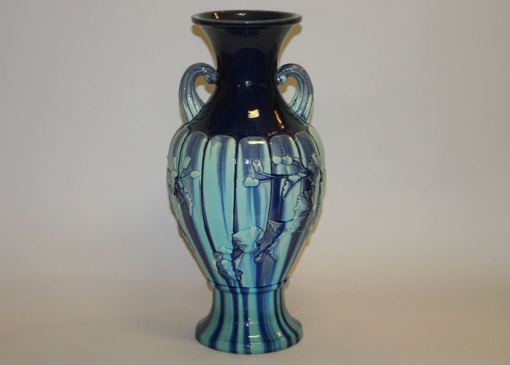 Large Japanese Kyoto pottery vase of baluster form with mid section divided vertically in lobes. Decorated with applied floral decor in crisp relief and brilliant violet over turquoise running glaze.