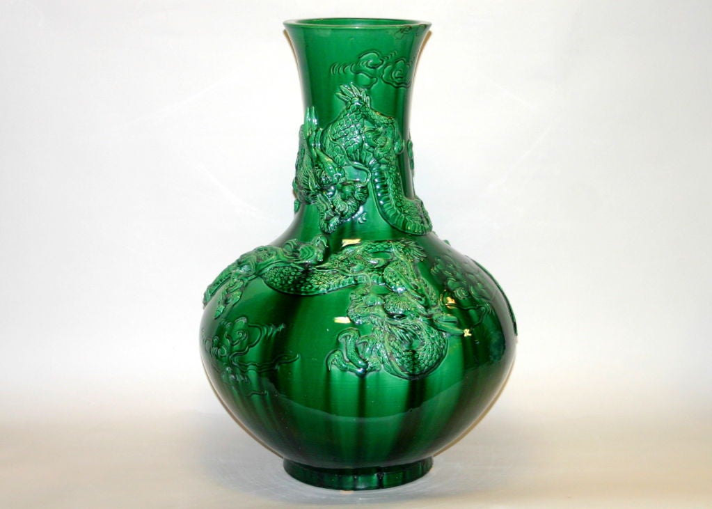 Japanese Awaji pottery vase in hu form with pair of opposing dragons floating amongst the incised clouds. Terrific emerald green glaze has streaked dark where it has been channelled by the decoration.