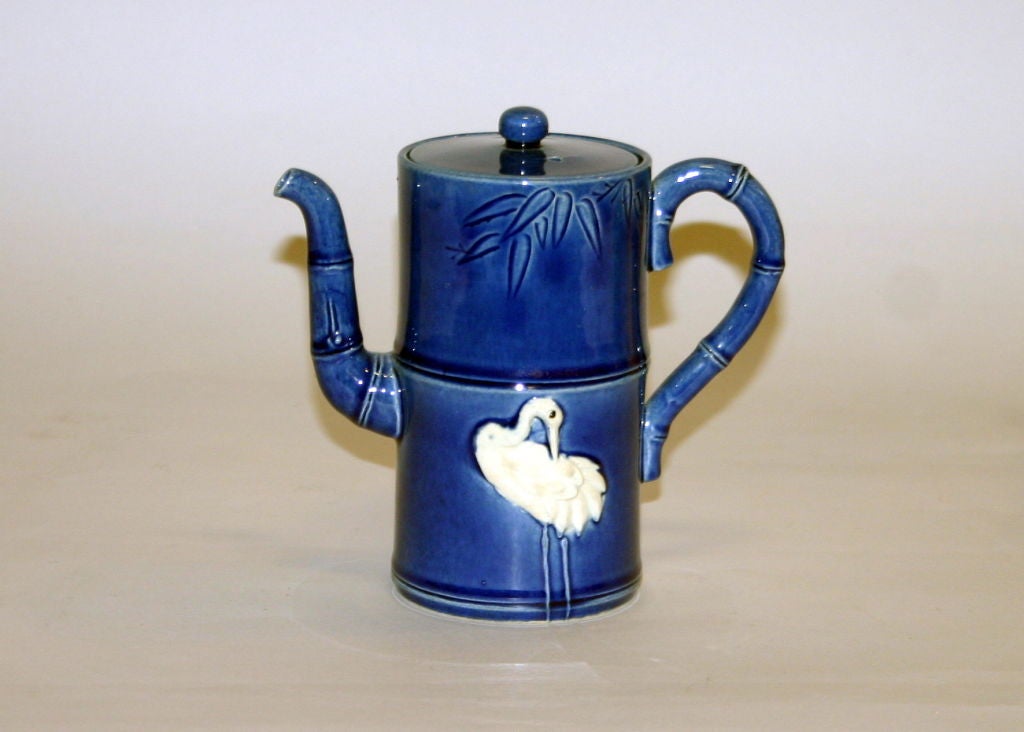 Awaji pottery teapot in segmented bamboo form with applied white cranes set against a deep blue ground. Impressed plover mark.