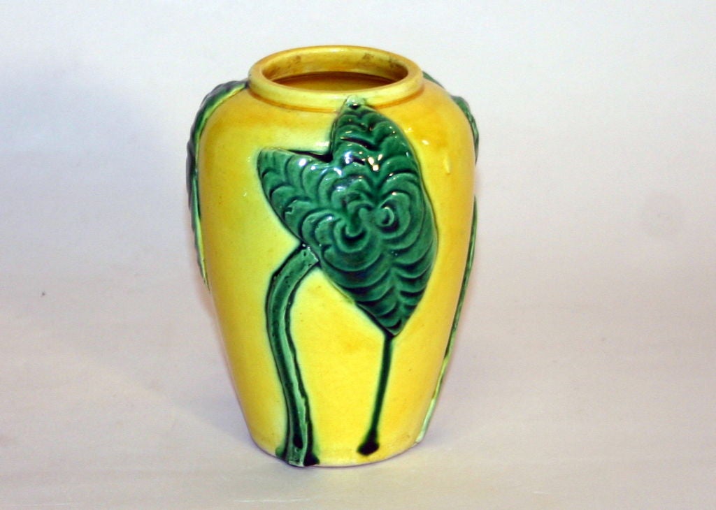 Hand made Awaji pottery vase with applied lily leaves in deep green on a lemon yellow ground.
