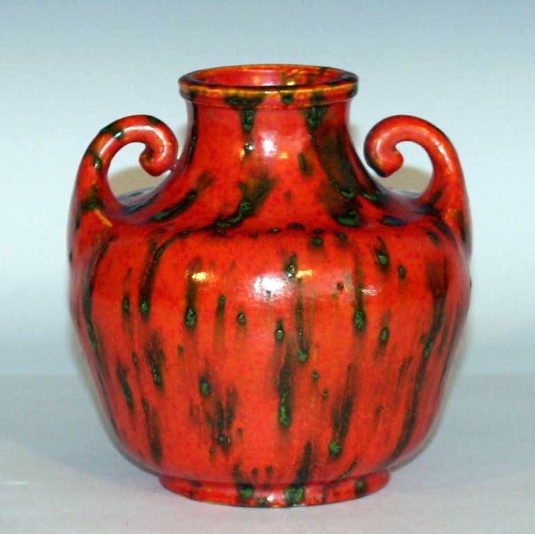 Awaji pottery vase with little upturned handles emanating from the wide shoulder and atomic orange and green flambe glaze, circa 1930. Impressed marks on base partially obscured by glaze. 6
