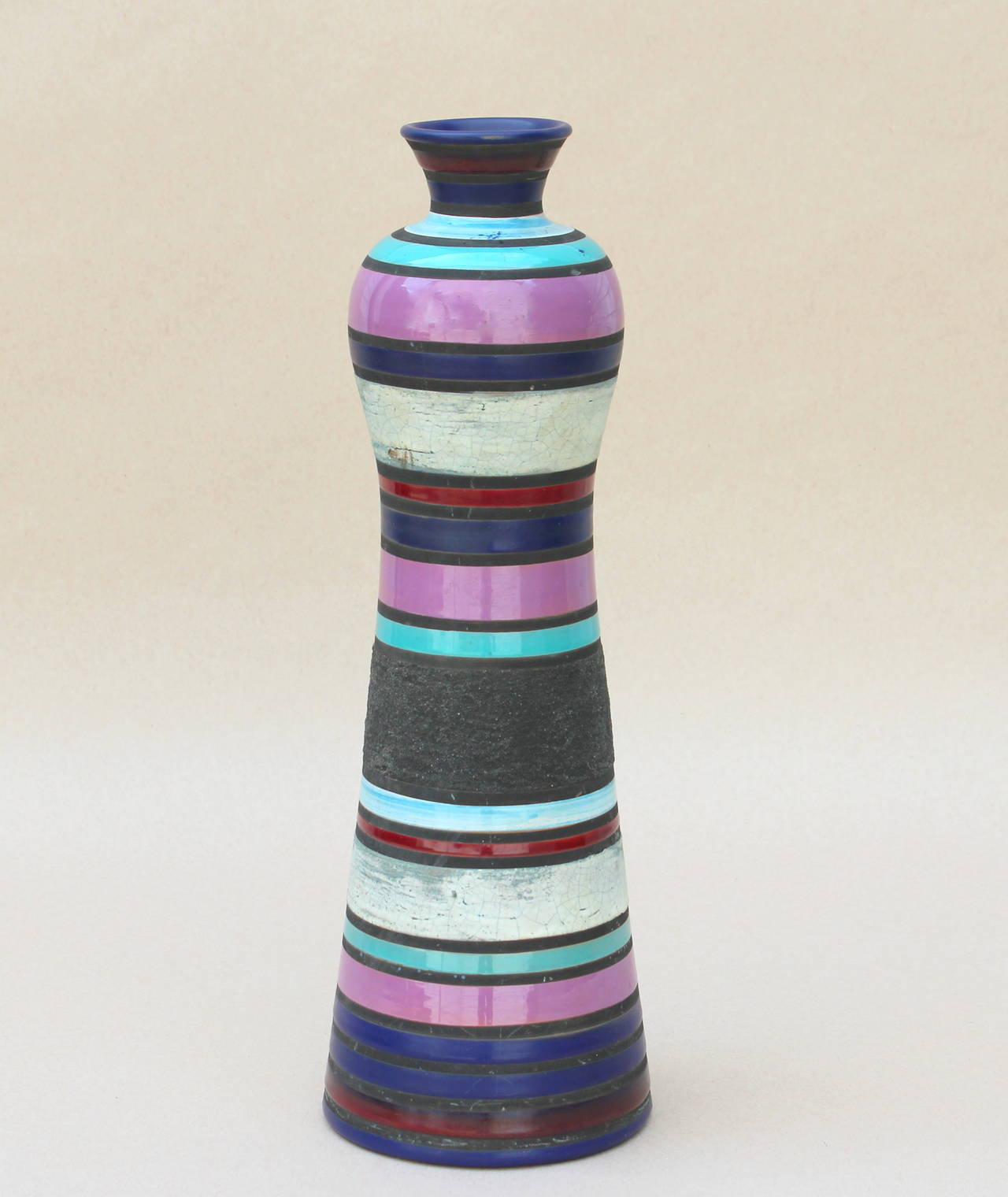 Early Bitossi vase designed by Ettore Sottsass, circa late 1950s. Of tall bottle form with bands of colored glaze in matte and gloss finishes. Retains original Raymor label with Bitossi code. Measures: 15