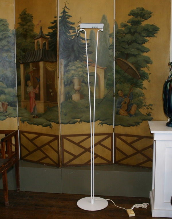 Floor lamp attributed to Sonneman with two arms rising from a circular base and supporting a pivoting halogen reflector. Toe touch dimmer switch.