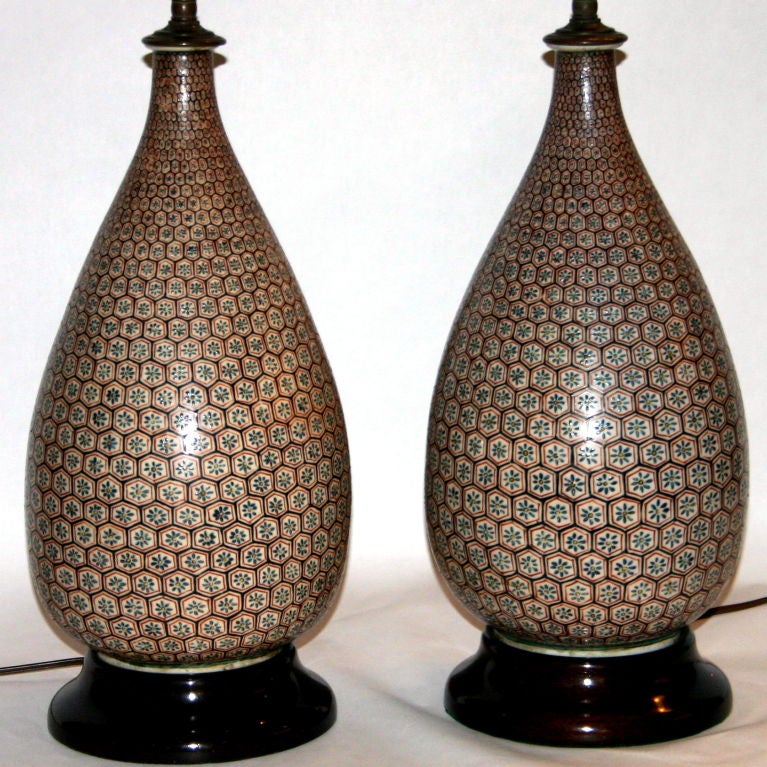 Pair antique Japanese Kutani porcelain sake bottles converted to double socket lamps. Painted with traditional Kutani colors in a diaper pattern of florettes.