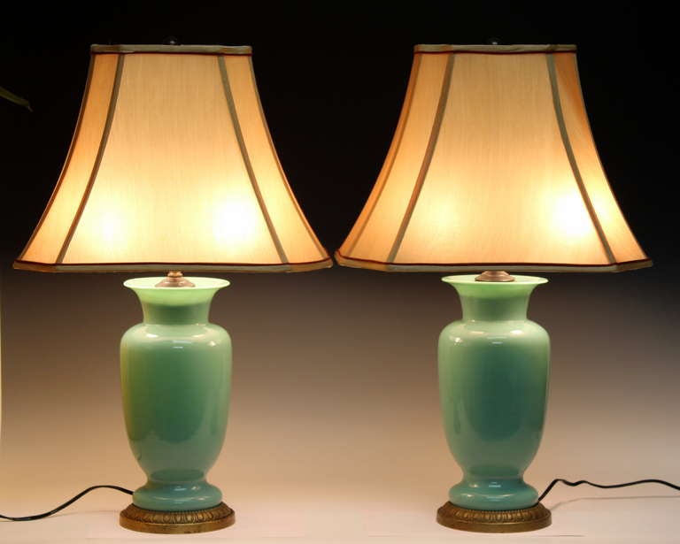 Pair of Paul Hanson lamps of sage green glass urns with brass hardware. New double socket clusters and wiring. Excellent condition. Shades not included, please inquire for availability/price.