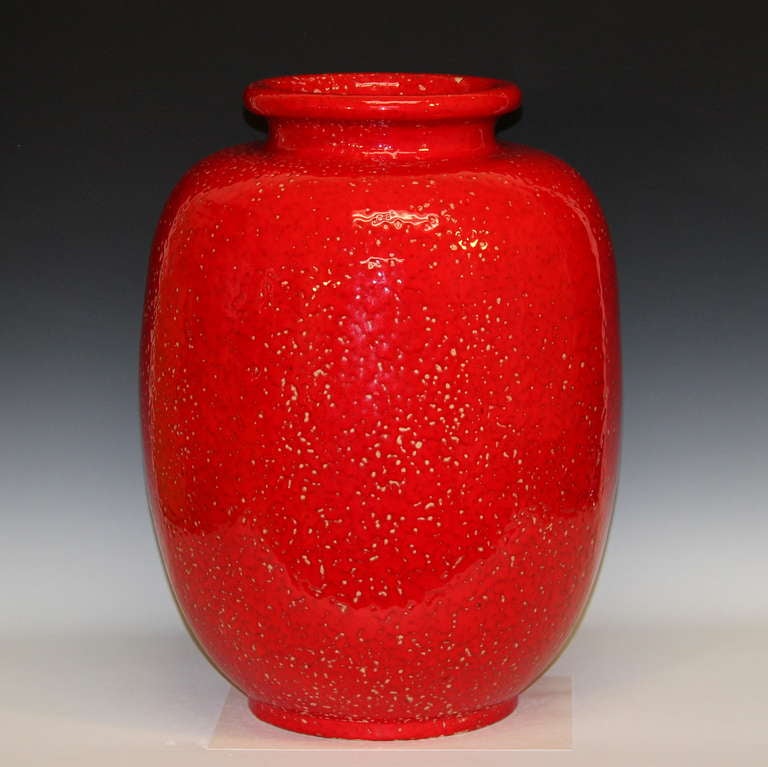 Richard Uhlemeyer vase in atomic red glaze. Well proportioned storage jar form with thick, mottled glaze. Double horsehead mark to foot and original paper label. One of the most celebrated names in West German Pottery is that of Richard Uhlemeyer