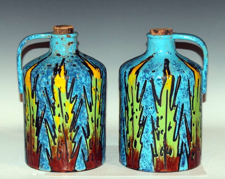 Pair of Italian whiskey or grappa jugs expressively decorated with fire-water flames, circa 1950s-1960s. Dimensions: 10 1/4