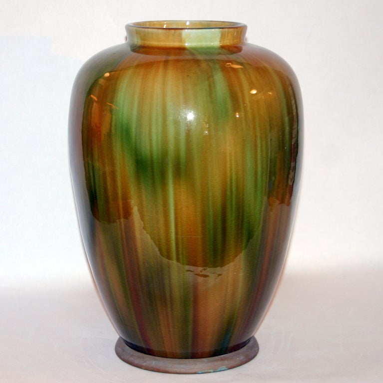 Large, antique, arts and crafts Wannopee Pottery vase in green and brown tiger's eye glaze. Copper foot mounted at base. Impressed Wannopee sunburst cipher on base.