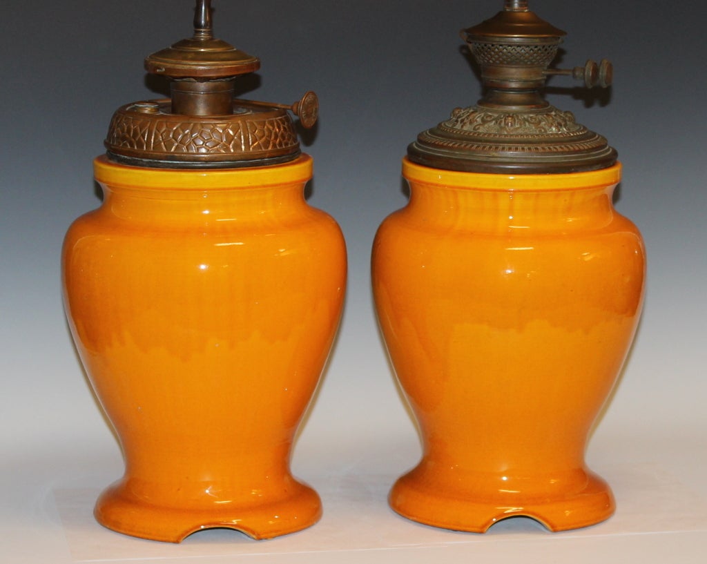 Pair Awaji pottery lamps converted from kerosene, with double cluster articulated sockets, and retaining the old reservoirs and wick controls.