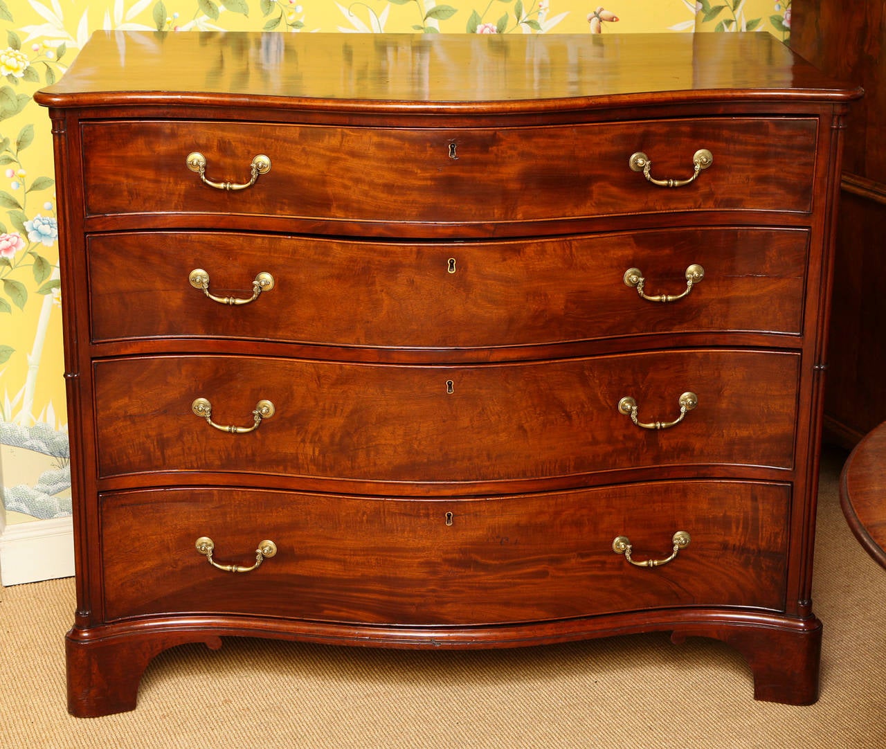 Fine antique large-scale Chippendale period serpentine mahogany chest of drawers, having a figured overhung thumb moulded top, above four figured graduated cockbeaded drawers and having cluster columns to the front corners. This Fine chest retains