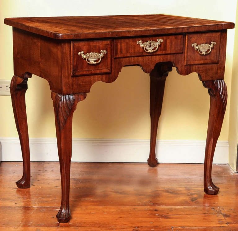 Very Fine &  Rare Irish George II Period Red Walnut Lowboy,having an overhang moulded rectangular top with crossbanding  above a shaped apron with three short crossbanded drawers retaining their original double dolphin stamped brasses, above four 