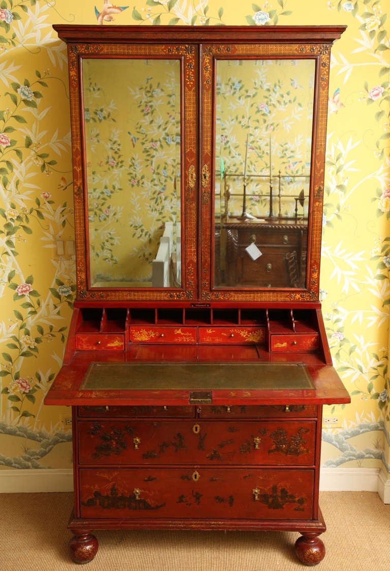 A fine William & Mary Red Japanned bureau bookcase with moulded cornice above two mirror glazed doors enclosing shelves, decorated in gold with birds, foliage and diaper pattern, the projecting bureau with sloping hinged flap enclosing pigeon holes,