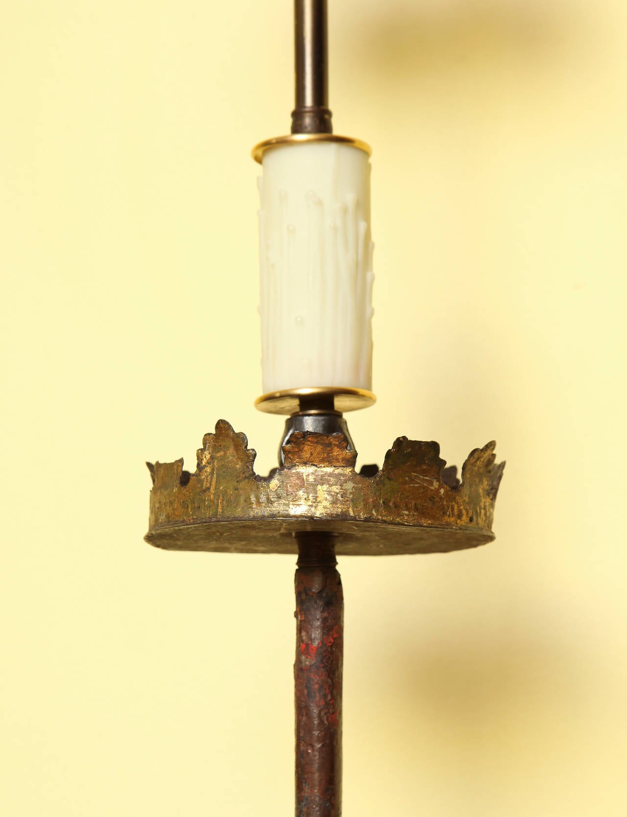 Baroque wrought iron torchere mounted as a floor lamp, having a knobbed round shaft with traces of polychrome paint and a gilt crown surmount, supported on three shaped downswept legs ending in penny feet. Now electrified, English or continental,