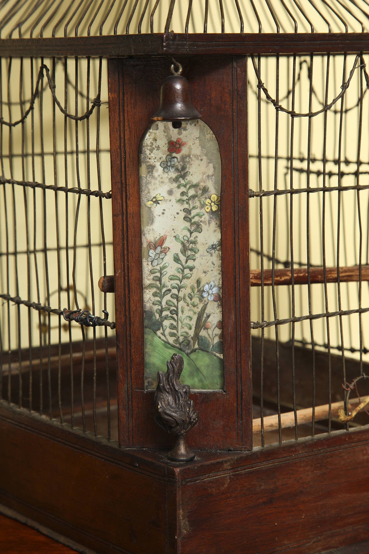 Rare Regency Chinoiserie Pagoda Form Brass and Mahogany Birdcage, the roof having pendant bells at each corner above canted reverse glass panels decorated with flowering branches. English circa 1820.