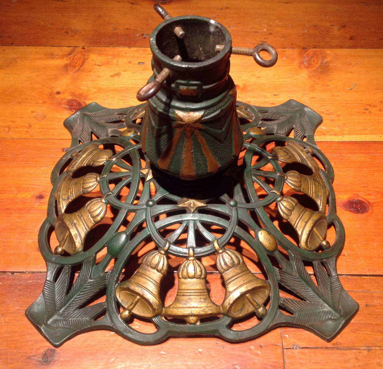 Very Fine Antique Cast Iron Christmas Tree Stand with a pieced base composed of four cartouches-each withthree golden bells bodered by a splayed foot decorated with pine boughs.  This piece retains the original green and gold washes and is large