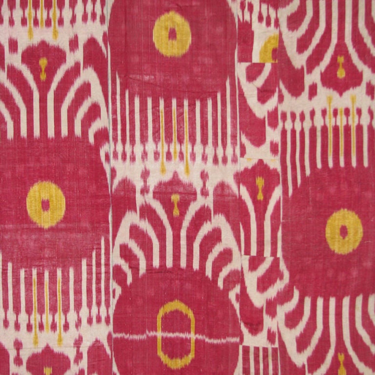 Large silk Ikat cover from Uzbekistan with large designs in raspberry red and yellow on a white ground. Piece is backed with origional printed cotton backing.