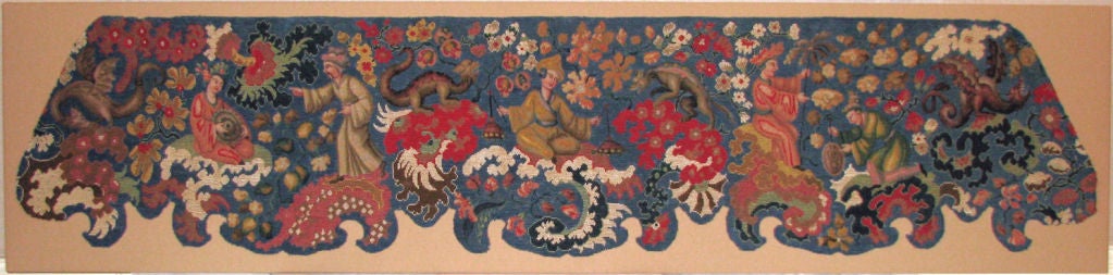 An exceptional 18th century French Chinoiserie needlepoint valence with a bright blue ground figured with Chinese stylized musicians with wonderful dragons nearby all amidst floral sprays. Mounted.