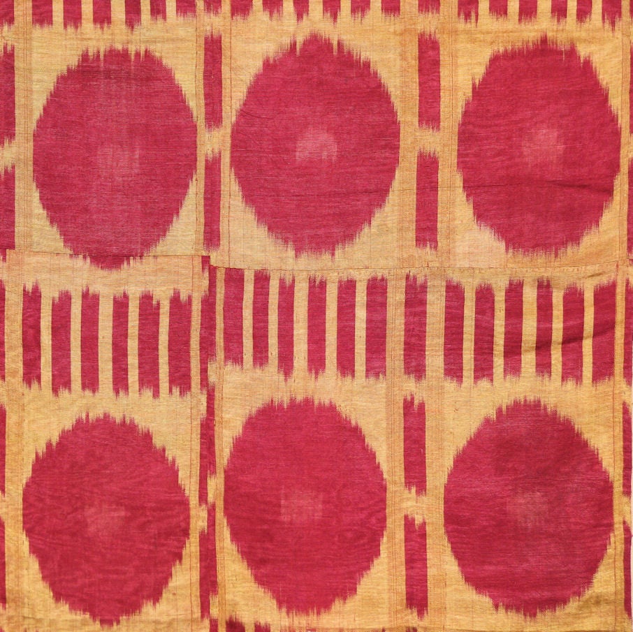 A late 19th/early 20th century silk ikat from Uzbekistan (possibly Bokhara) with a yellow ground patterned with a raspberry pink colored abstract floral design with vertical bars above and below.<br />
<br />
Ikat designs are meant to be