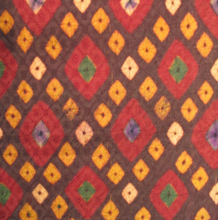 A late 19th century ceremonial cloth made from a lattice patterned silk damask, stitch-resist tie-dyed from the Cham people of Cambodia. Aubergine colored ground with a small trellis pattern outlined by resist dyed squares of yellow and