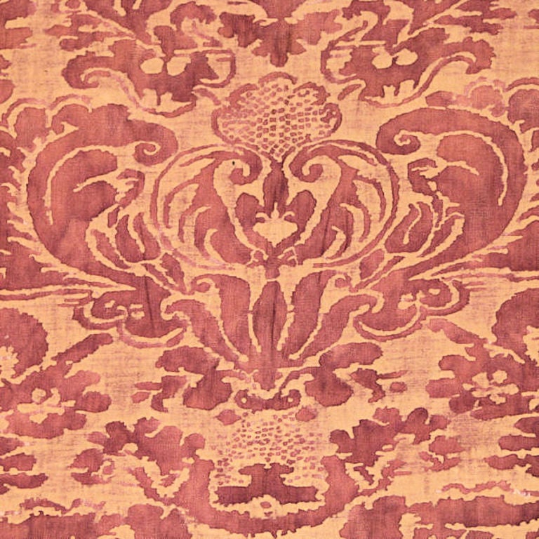 Early 20th century Mariano Fortuny (Venice, Italy) stenciled cotton with a foliated leaf and crown design. The design is stenciled in a faded red color on a mottled butterscotch colored ground. Edge is trimmed with Fortuny tape.