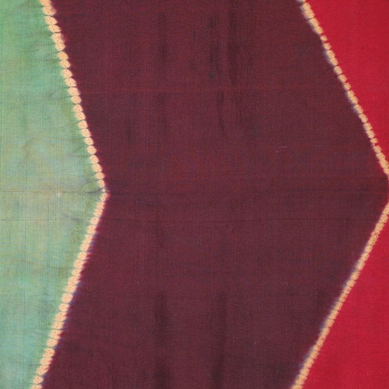 A late 19th century lawon, a ceremonial presentation scarf worn by a married woman. This multicolored silk cloth was resist dyed in a process called plangi or pelangi, literally meaning rainbow. From Sumatra, Indonesia. Mounted.