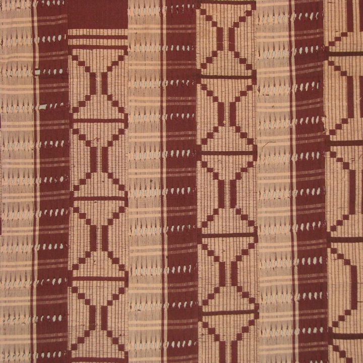 A mid 20th century Nigerian 'Yoruba Aso Oke Cloth' brown cotton with eyelets with surface weft geometric pattern in off while cotton thread.