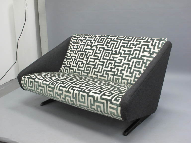 Vintage Italian aerodynamic loveseat on wood slat legs, newly reupholstered in a green geometric velvet and grey flannel arms.

If you would like to see this piece in person, please contact us to schedule a viewing.