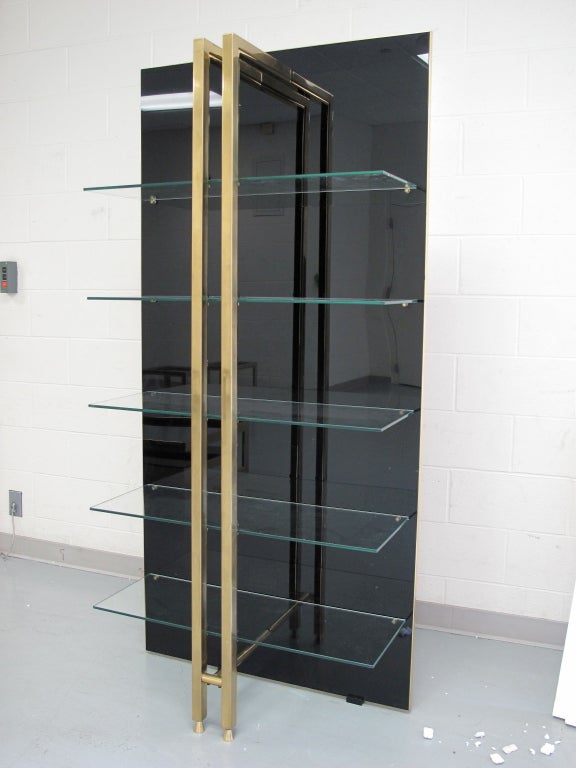 1970's Italian brass and black plexi bookcase/étagère with floating clear glass shelves.

As this piece may be in our off-site storage, please call ahead to schedule a viewing.