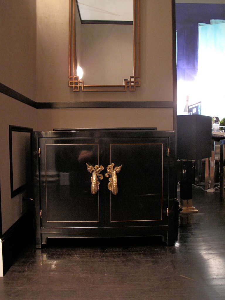 Vintage Chinoiserie style black lacquer two door cabinet with bronze dragon fixtures. Interior is lacquered in vibrant green.