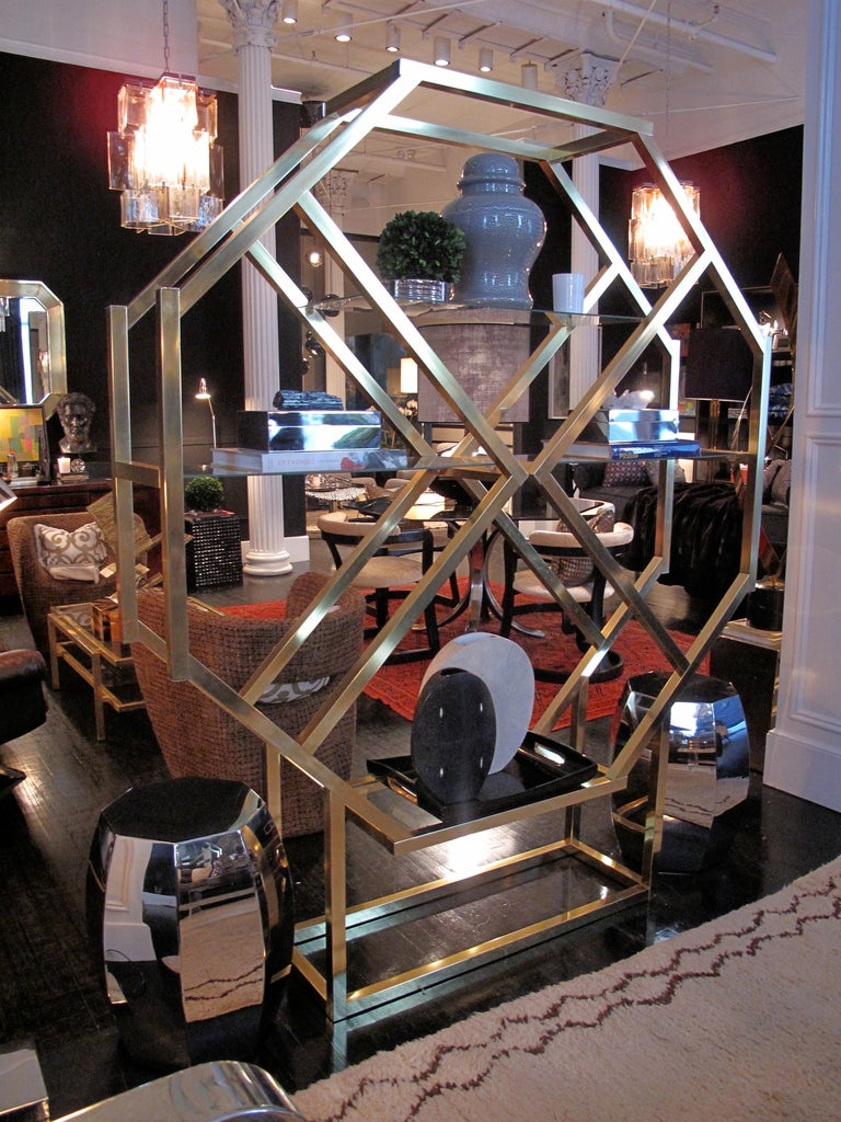 Brass octagonal etagere/room divider with four glass shelves in the style of Milo Baughman.

If you would like to see this piece in person, please contact us to schedule a viewing.
