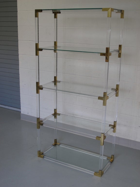 French 1970's square Lucite bar and brass corner detail etagere with glass shelves.

As this piece may be in our off-site storage, please call ahead to schedule a viewing.