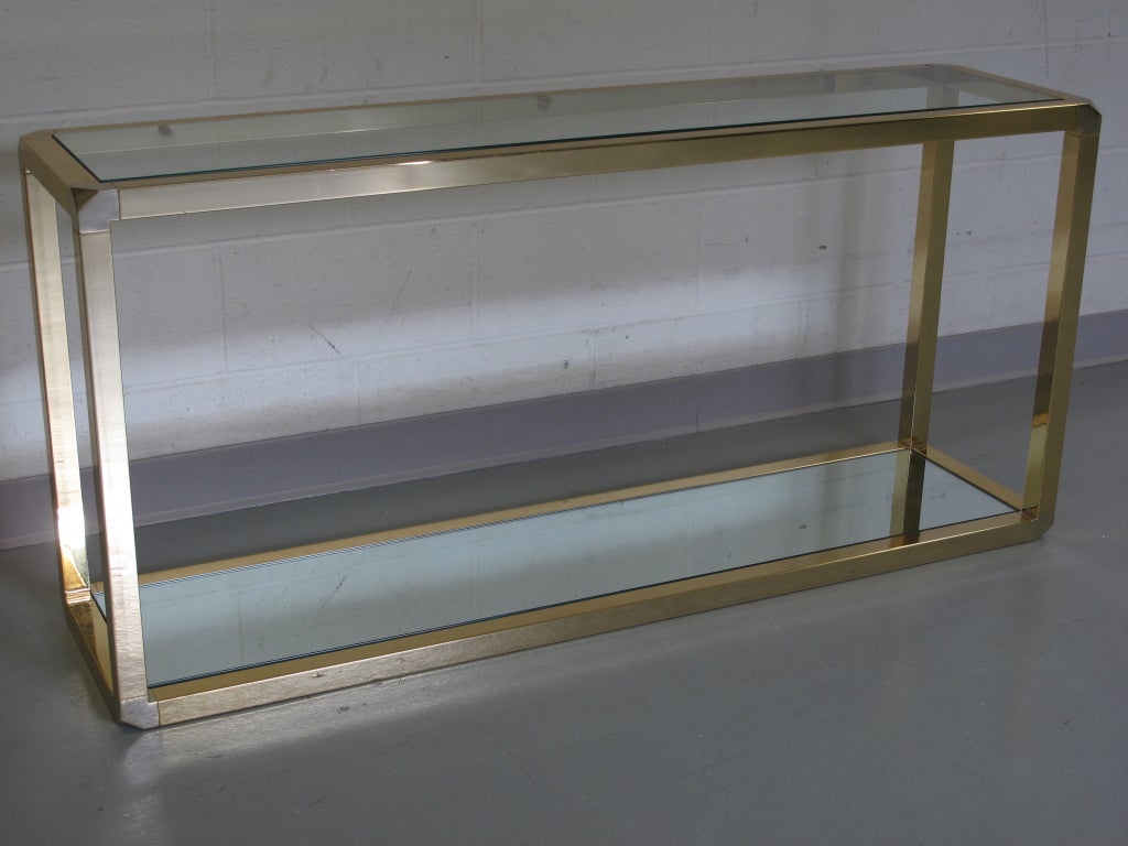 Two-tiered brass console table with faceted corners and mirrored lower shelf. France, 1970s.
 