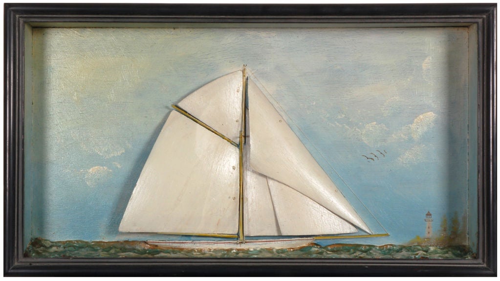 18” x 10”   2” deep,  American half ship diorama model of a  fractionally rigged sloop under sail, off a headland with lighthouse.  circa l880. Framing restored.