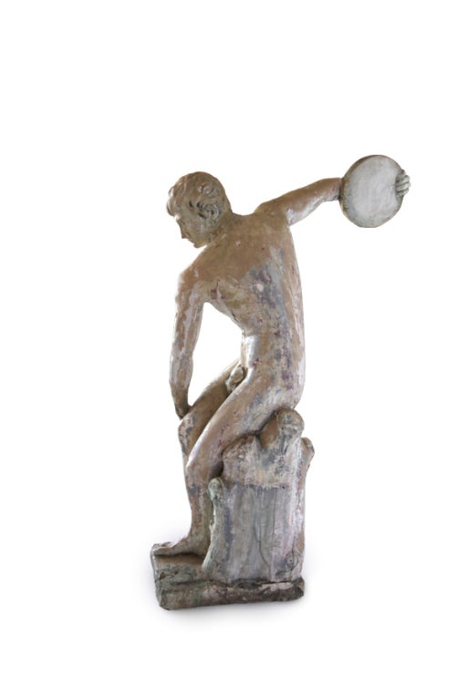 Antique French statue of a disc thrower that was once in a garden of a chateau outside of Versailles. Graceful form and remnants of old paint give this piece beautiful character.