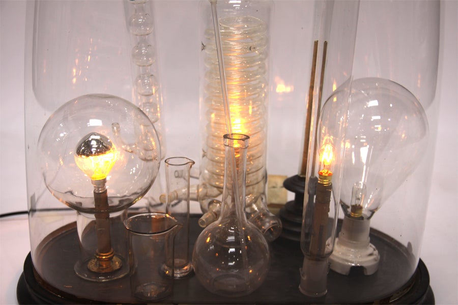 Modern light sculpture designed by French Designer, showcases industrial light bulbs encased in an antique glass globe.