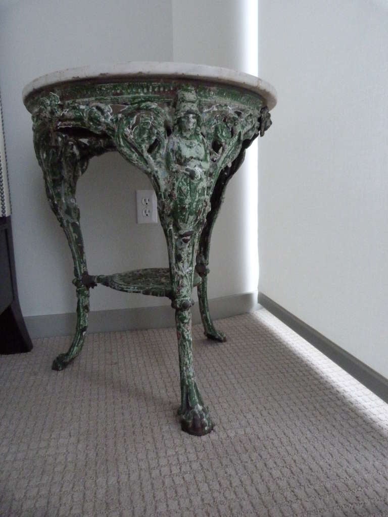This table has beautifully patinated green painted metal base with carrera marble top.