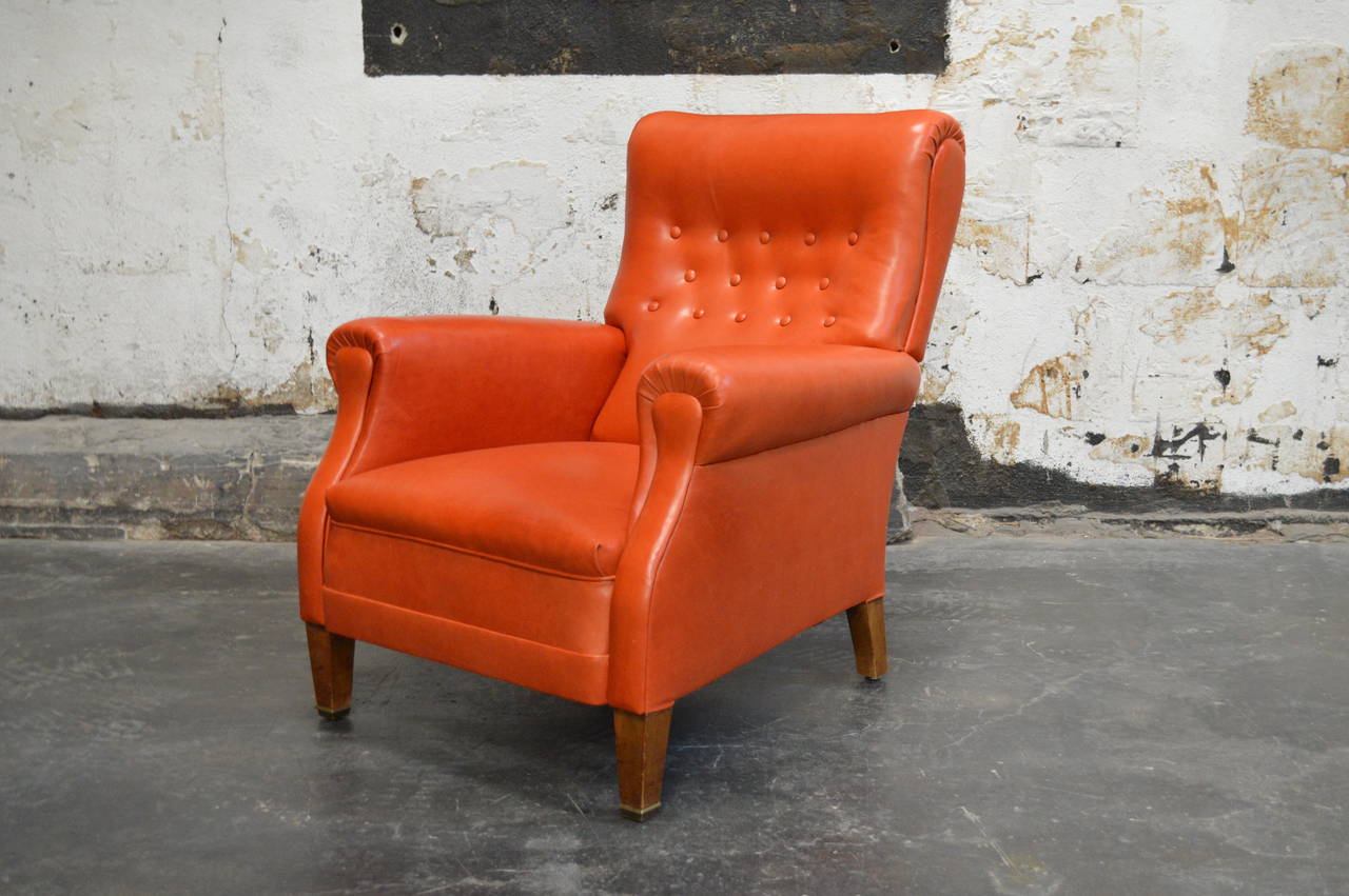 Vintage Swedish lounge chair newly restored and upholstered in orange leather. Extremely comfortable lounge chair perfectly scaled for just about any room. The sculptural button tufted back gives this chair a modern flair.