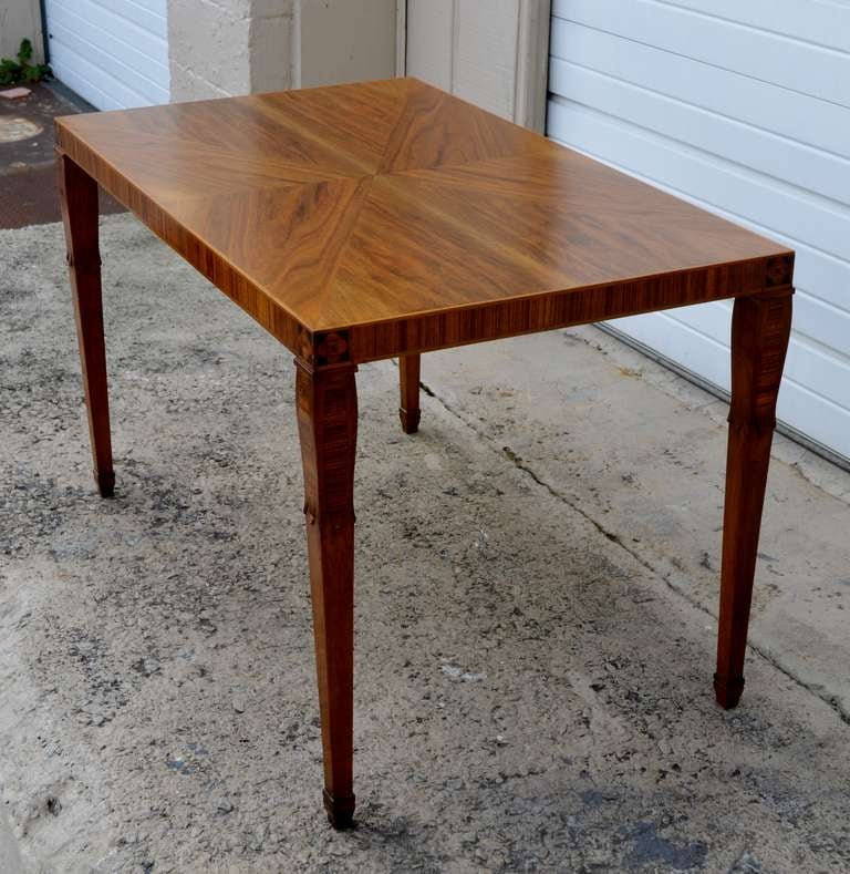 Book-matched walnut top, Rosewood trim with intarsia at
corners, tapered legs in walnut and inlaid rosewood and
carving at top. Marked 
